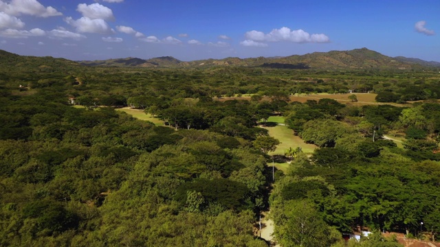 空中向前:树覆盖，阳光灿烂的平原和远处的山脉-埃尔吉甘特，尼加拉瓜视频素材
