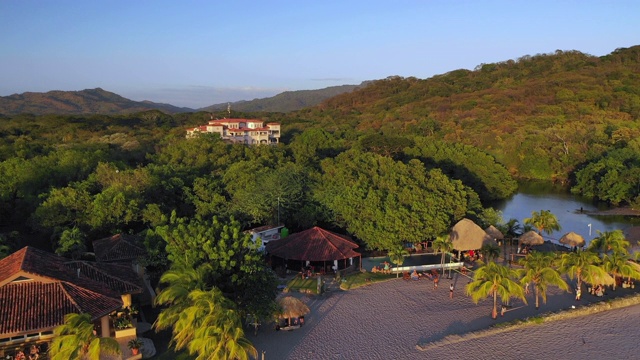 空中降落:尼加拉瓜埃尔吉甘特海滩沙滩上的房屋和居民视频素材
