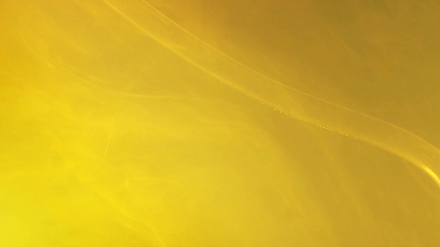 黄色的丙烯酸漆均匀地溶解成水，近景。模糊的背景。黄色液体颜料，丙烯酸油墨，抽象图案视频素材