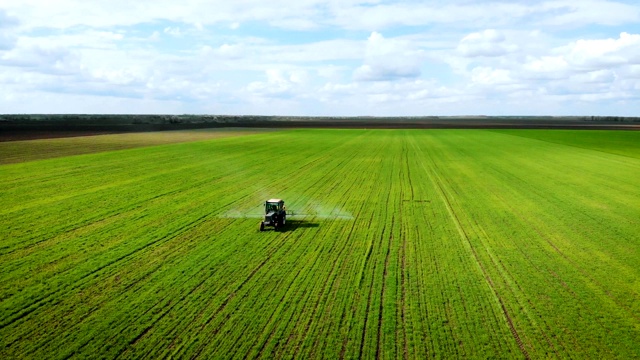 装有农业喷雾器的拖拉机给粮食作物施肥的鸟瞰图视频素材