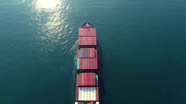 鸟瞰图集装箱船满载集装箱在绿色海洋上物流，航运，进出口或运输。视频素材