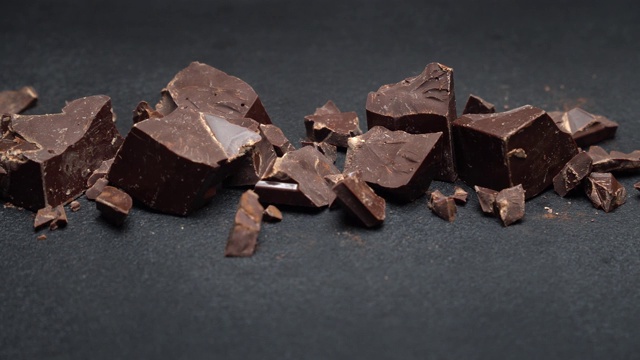 深色或牛奶有机巧克力块在深色的混凝土背景上视频素材