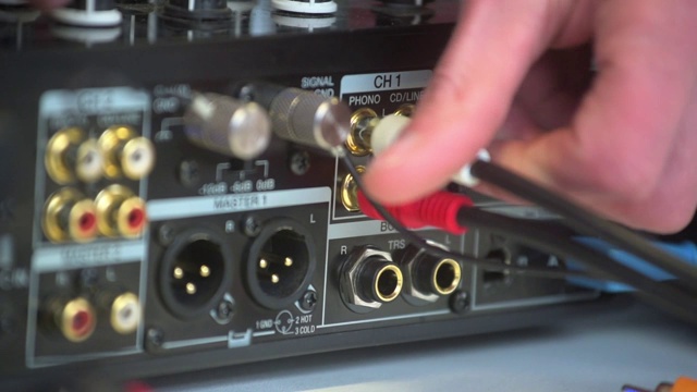 男子的手插在dj音频混音工作室设备。近距离观察不同颜色的电源插头视频下载