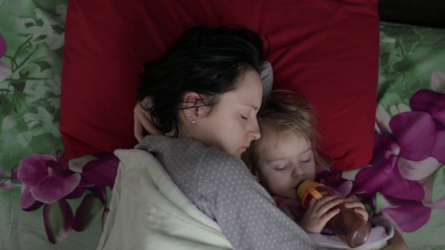睡意朦胧的年轻女子抱着她的孩子不想在早晨醒来视频素材