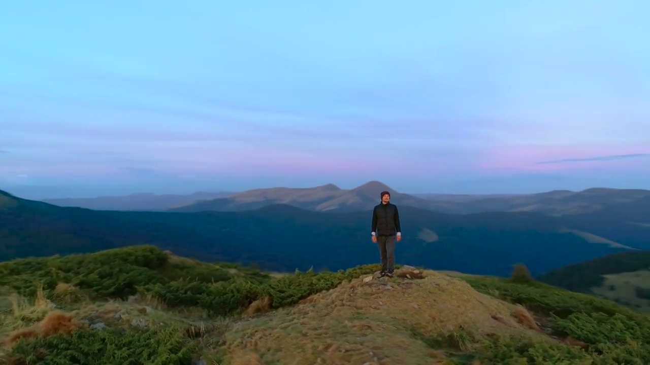 一个在美丽的日出中站在山顶的人视频素材