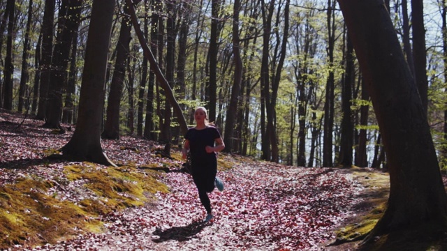 年轻女子在森林里奔跑。视频素材