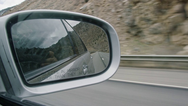 70号州际公路，汽车，科罗拉多州的落基山脉，以及汽车侧镜反射出的多云天空(镜中的物体比它们看起来更近)视频下载