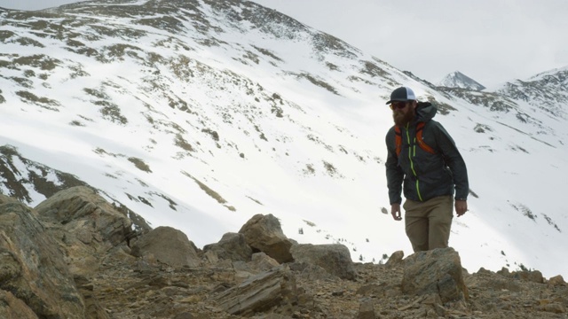 一名二十多岁、留着胡子的高加索男子背着背包，在科罗拉多州落基山脉的洛弗兰山口(大陆分水岭)附近的一座山中徒步旅行视频素材