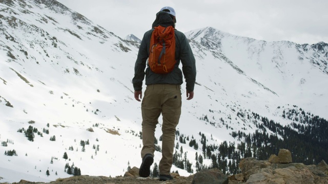 一名二十多岁、留着胡子的白人男子背着背包，在科罗拉多州落基山脉的Loveland Pass(大陆分水岭)上徒步登山视频素材