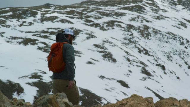 一名二十多岁、留着胡子的高加索男子背着背包，在科罗拉多州落基山脉的洛弗兰山口(大陆分水岭)附近的一座雪山上徒步旅行视频素材
