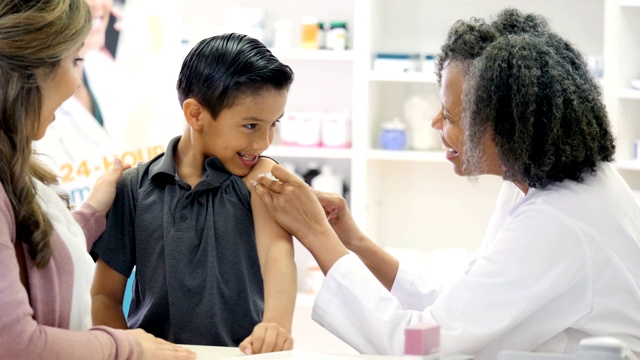 接受疫苗后，女药剂师在男孩的手臂上贴绷带视频下载