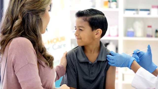 一个小学生在药剂师给他注射流感疫苗时做鬼脸视频下载
