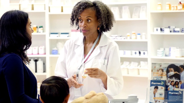 成熟的非裔美国女性药剂师向女性顾客解释药物的副作用视频素材