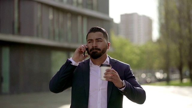 男人用智能手机说话，用户外纸杯喝水视频素材