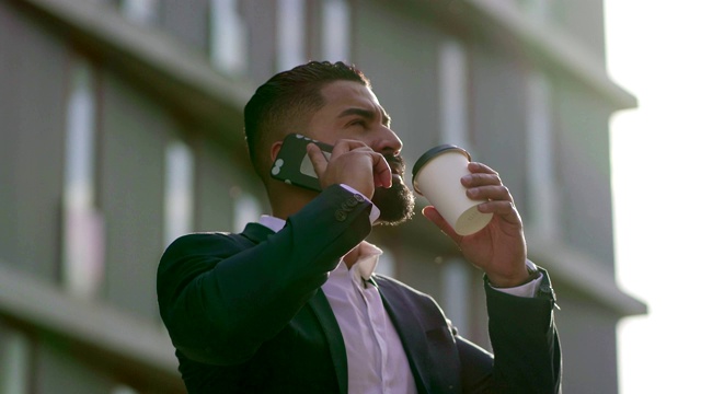 男人用纸杯喝水，用智能手机聊天视频素材