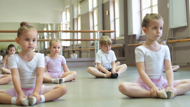 小芭蕾舞演员和芭蕾舞演员在芭蕾课前做伸展运动视频素材