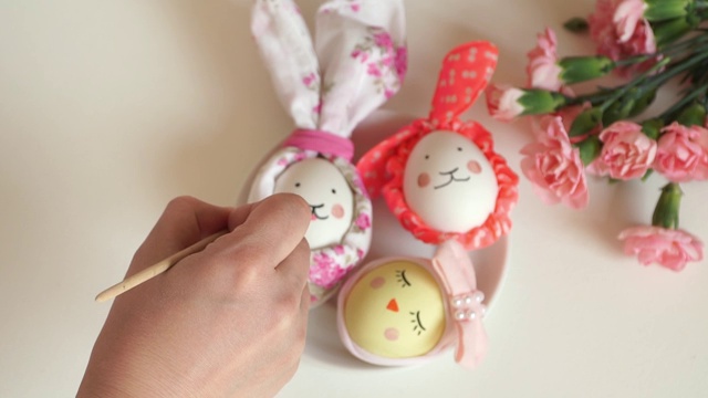 特写的女性手与毛笔绘制鸡复活节彩蛋装饰复活节兔子和鸡视频素材