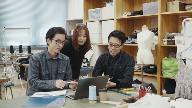 这是三个在纺织厂电脑前工作的中年设计专业人士的中影视频素材
