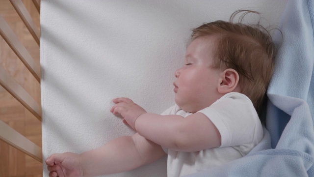 一个漂亮的婴儿安静地睡在他的婴儿床里视频素材