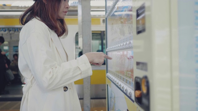 亚洲女性用智能手机在自动售货机上付款。视频素材