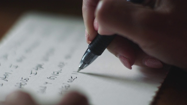 ECU SLO MO，一个成熟的女人用水墨笔在明信片上写一封私人信件。视频下载