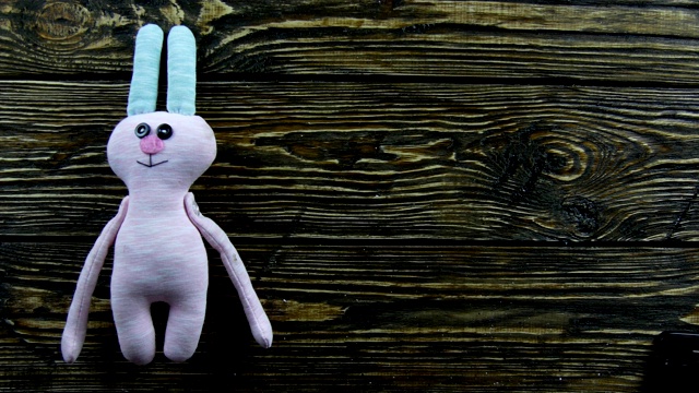 木制背景上的毛绒野兔玩具视频下载