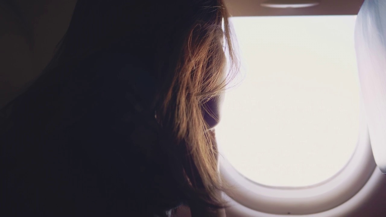 亚洲女游客在飞机上打开窗户视频素材