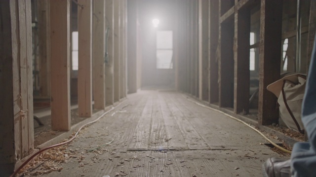 SLO MO:总承包商走在废弃建筑的旧木地板上。视频下载