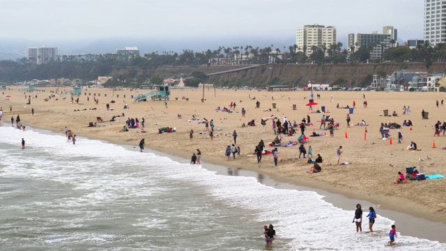圣塔莫尼卡海滩游客在阴天享受大海的广角镜头视频下载