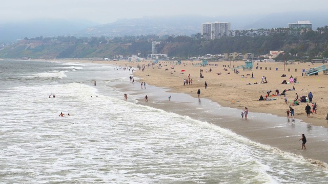 圣塔莫尼卡海滩游客在阴天享受大海的广角镜头视频素材