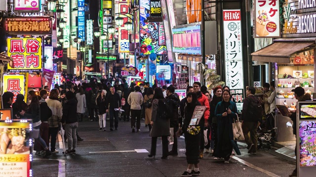 在日本东京新宿，一群人在购物霓虹街道和车流交叉人行道上行走的4K时间间隔。日本文化和城市生活理念视频素材