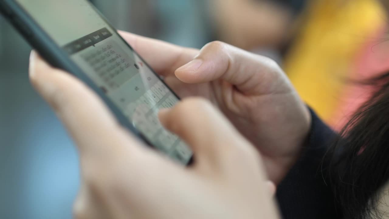 近距离拍摄的女商人在地铁上用智能手机发短信的慢镜头视频下载