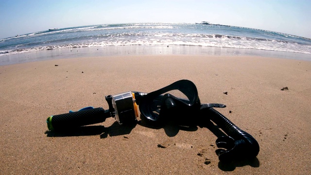在海边的沙滩上戴着水下面罩和摄影机视频下载