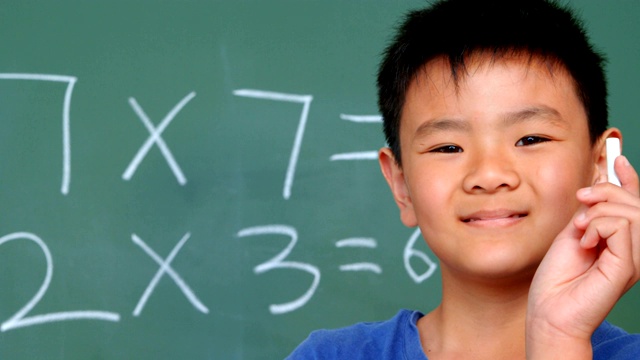 正面的亚洲学生站在黑板和显示粉笔在教室4k视频下载