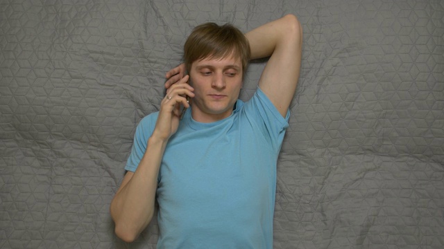一个年轻人在床上打电话视频下载