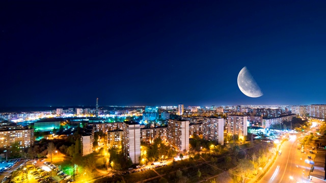 月亮背景下的夜晚城市。时间流逝视频素材