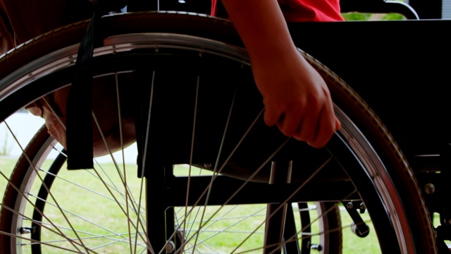 侧面的残疾非洲裔美国男孩移动他的轮椅在学校走廊4k视频下载