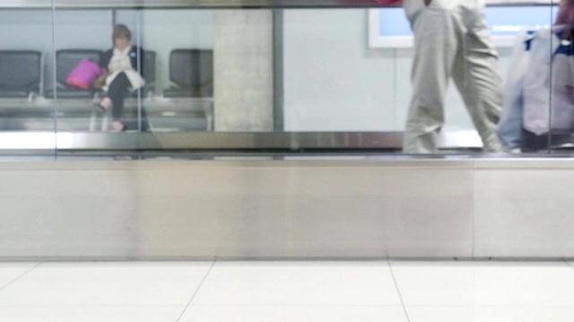 慢镜头模糊了在机场候机楼机械步道上移动的人、游客或乘客视频素材