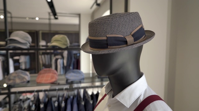 一个男性模特戴着时髦的帽子在昂贵的奢侈品牌男装精品店的特写。时尚行业的业务视频素材