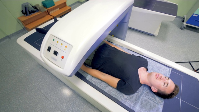 一位成年男子正在接受医疗机器的扫描。x射线的过程。视频下载