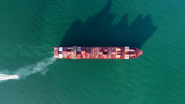 鸟瞰图集装箱船在海上到码头进行物流，航运，进出口或运输。视频素材