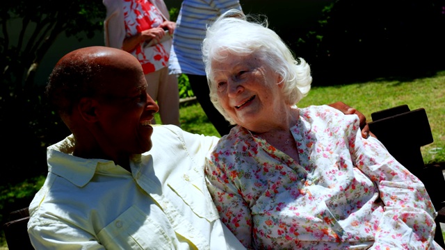 正面的积极混合种族的老夫妇微笑和看着对方在努尔的花园视频素材