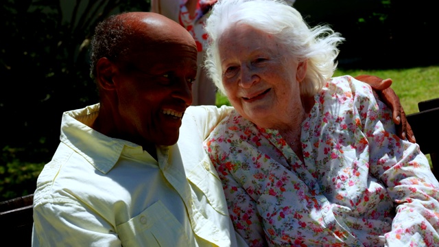 正面的积极混合种族老年夫妇拥抱对方在花园的养老院4k视频素材