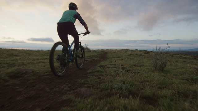 两名骑手(一名女性和一名男性)山地自行车在洛基山脉以西的丹佛，科罗拉多州日出视频下载