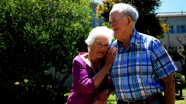 正面的观点积极的白人老年夫妇散步在花园的疗养院4k视频素材