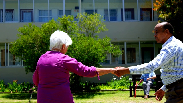 积极的混合种族的老年夫妇在花园跳舞在4k护理之家视频下载