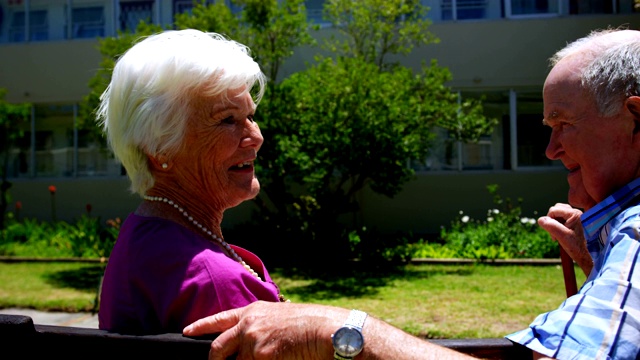 积极的白种老年夫妇在养老院的花园中相互交流的侧视图视频素材