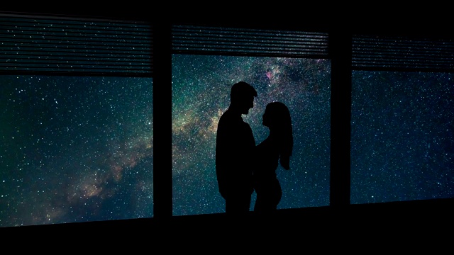 在星空的背景下，这对男女站在窗前。时间流逝视频素材