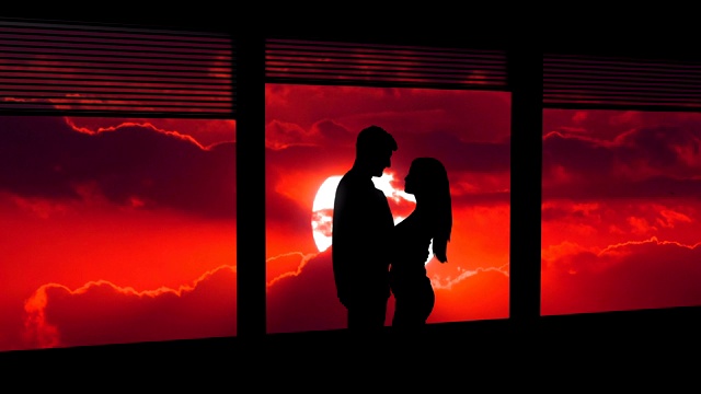 男人和女人站在窗边，背景是明亮的太阳。时间流逝视频素材
