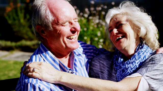 正面的积极白人老年夫妇拥抱对方在花园的养老院4k视频素材